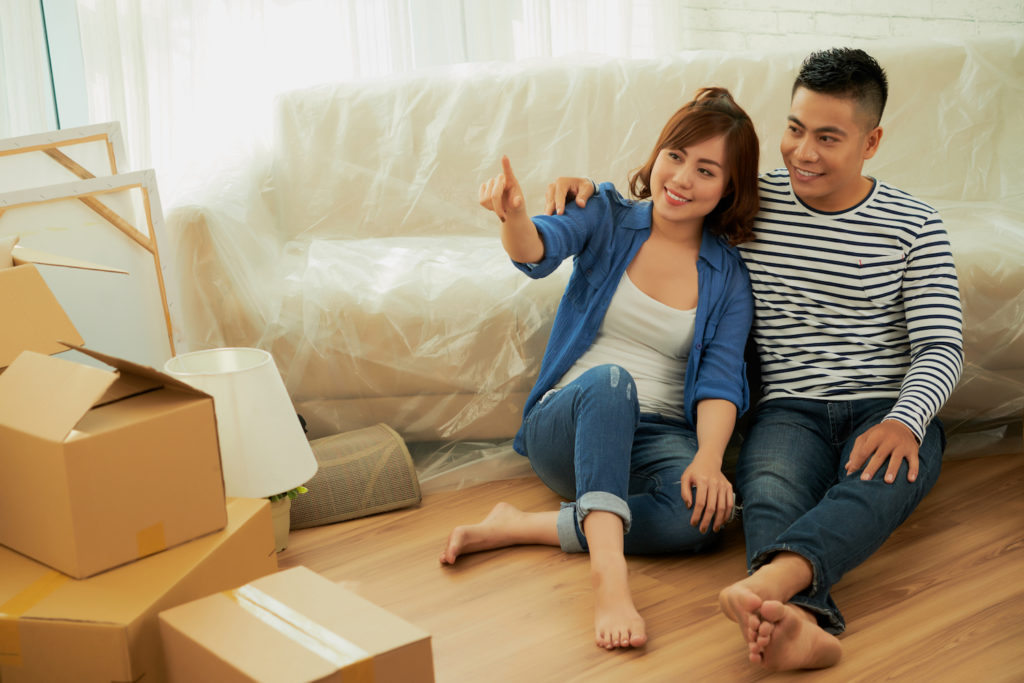 Man and woman on floor by boxes in house
